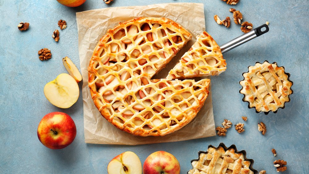 Tasty apple pies on color background