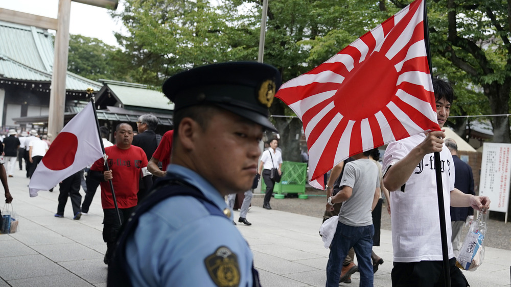 Man carries a Japanese imperial flag 