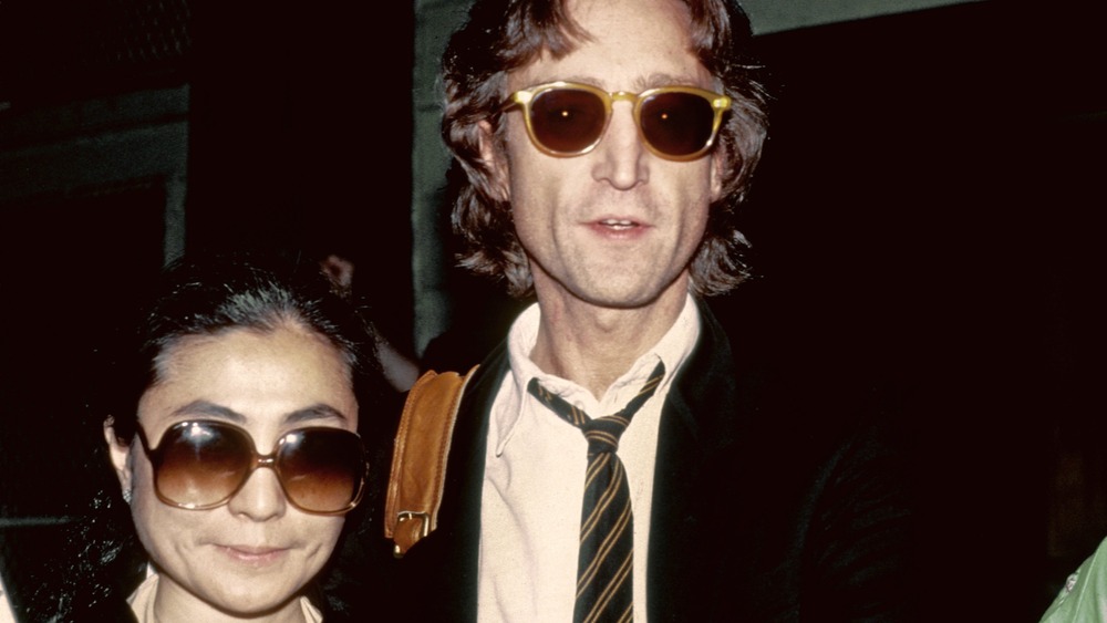 John Lennon with Yoko Ono wearing sunglasses