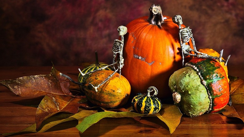 Small skeleton figures on pumpkins