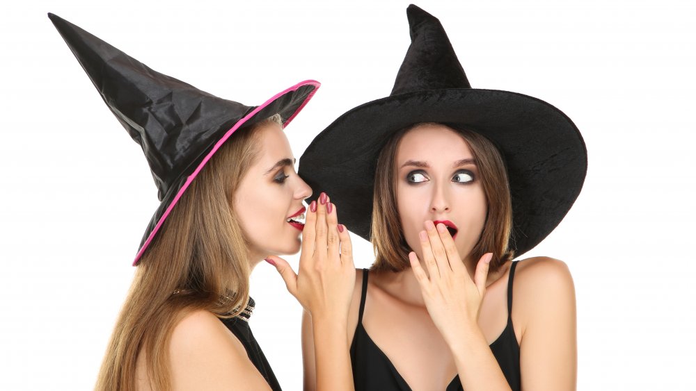 Women dressed as witches whispering