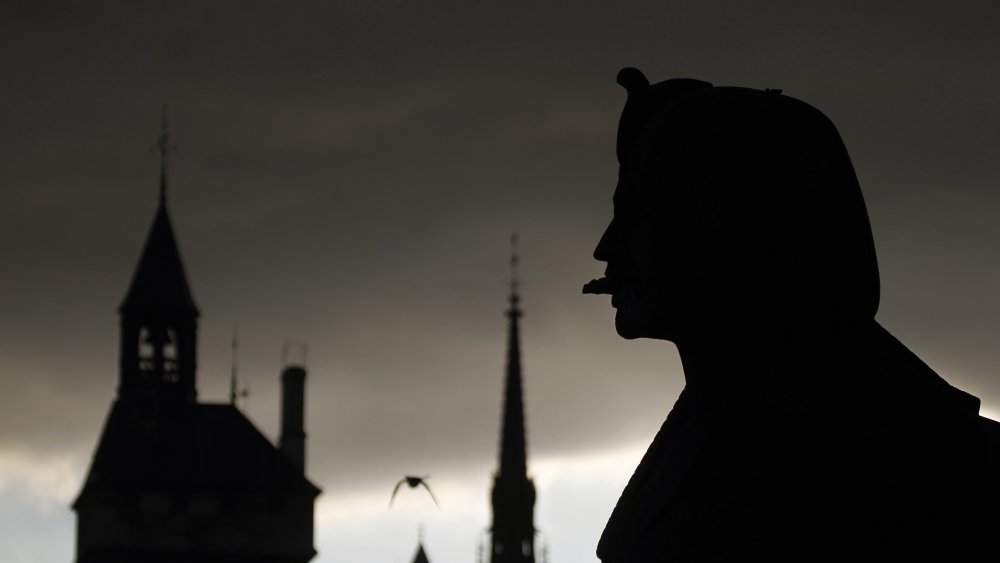 A sphinx of the Palmier fountain (R), the tower of the conciergerie (L) and the spire of the Sainte-Chapelle. 