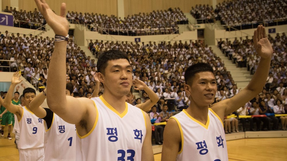 North and South Korean basketball players enter the field.