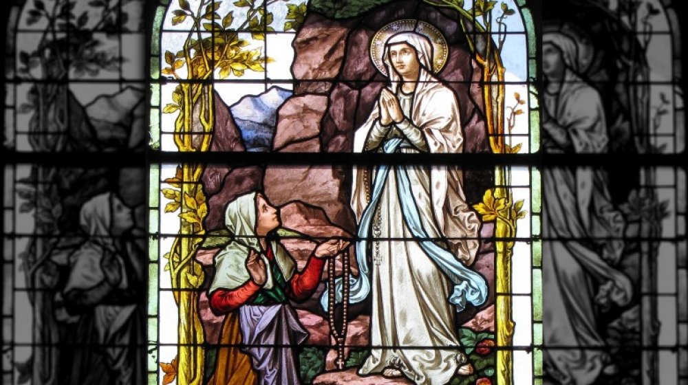 Stained glass window showing the Virgin Mary appearing to Bernadette Soubirous