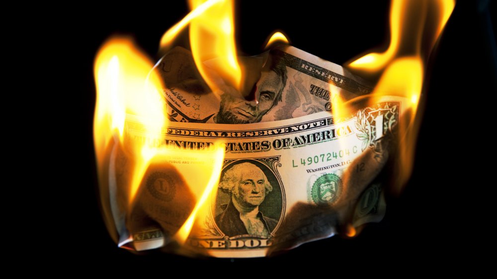 A burning 1-dollar and 5-dollar bill.