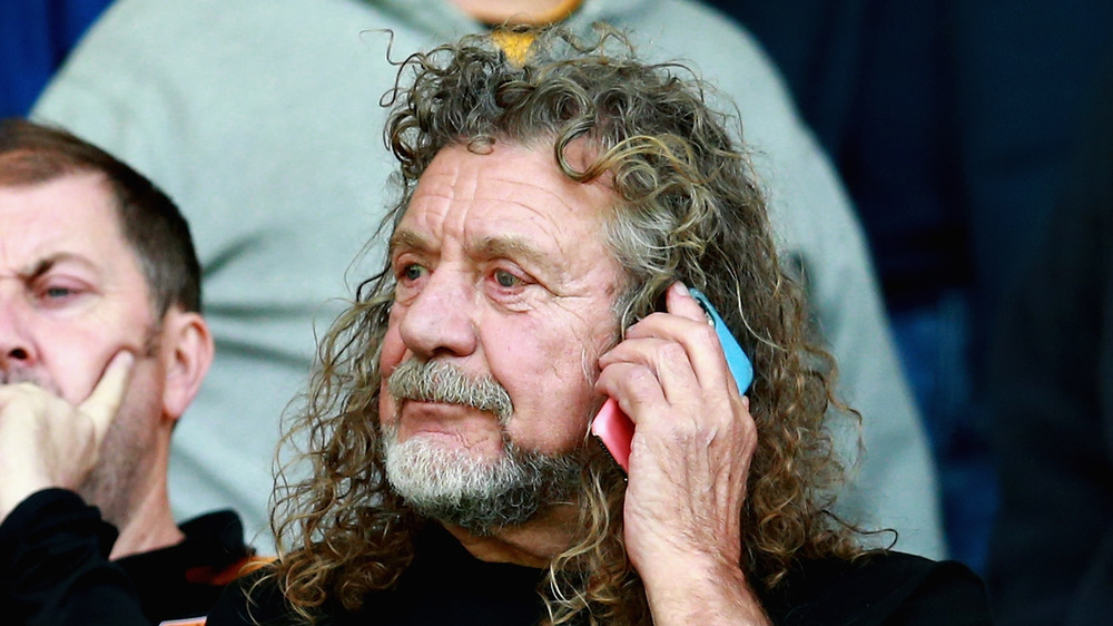 Led Zeppelin singer Robert Planet on his phone at a soccer game in 2018