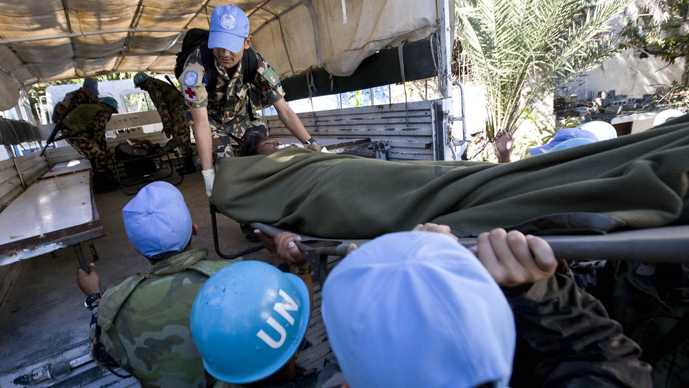 JANUARY 13: In this handout image provided by the United Nations, United Nations Stabilization Mission in Haiti (MINUSTAH) peacekeepers load an injured person into a truck after an earthquake on January 13, 2010 in Port-au-Prince, Haiti.
