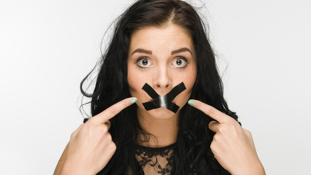 An indignant woman with her mouth taped shut