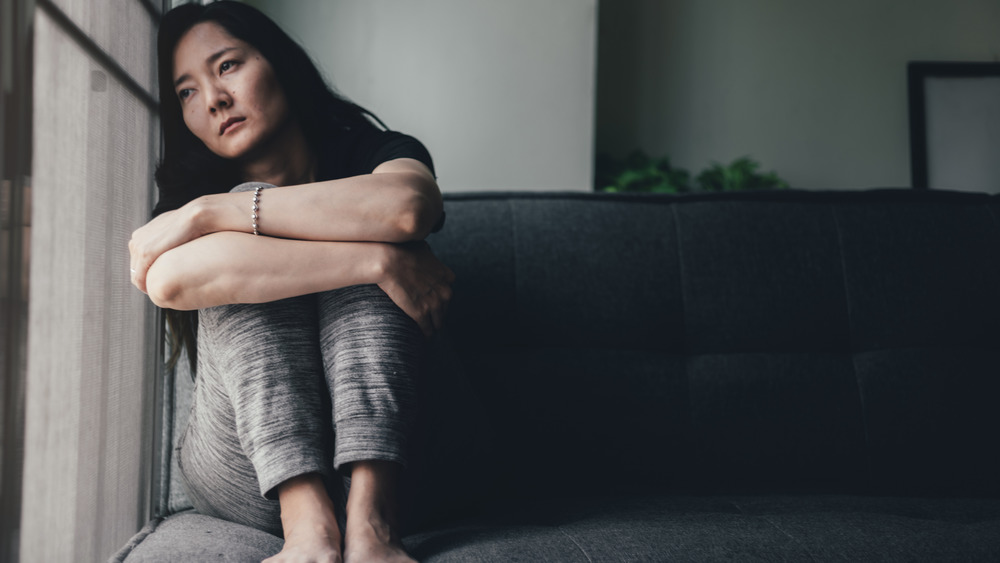 Depressed woman sitting curled up