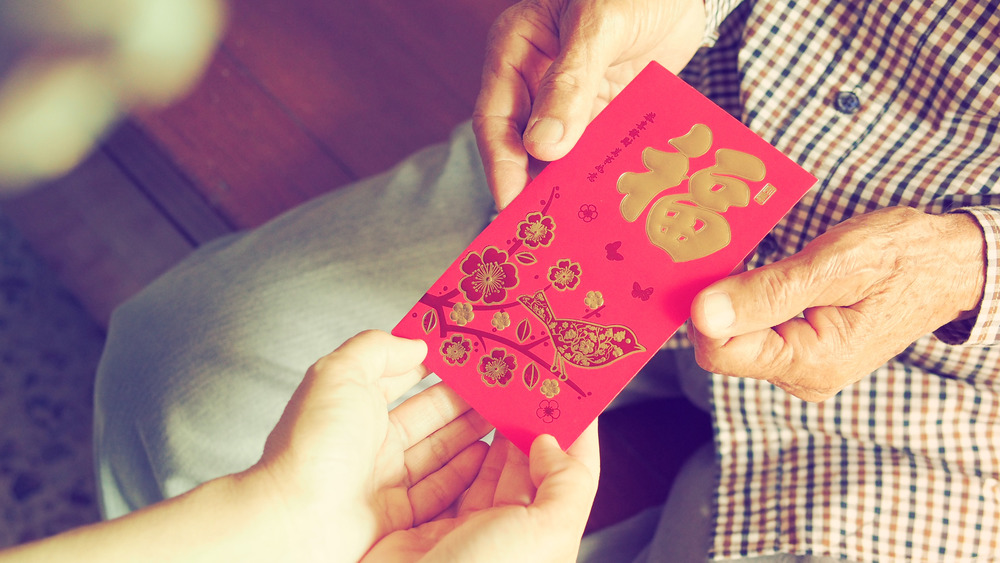 people exchanging red envelopes