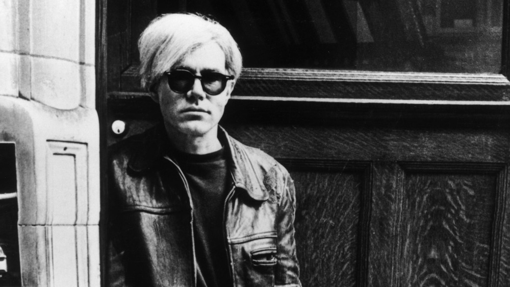 Andy Warhol standing in a doorway