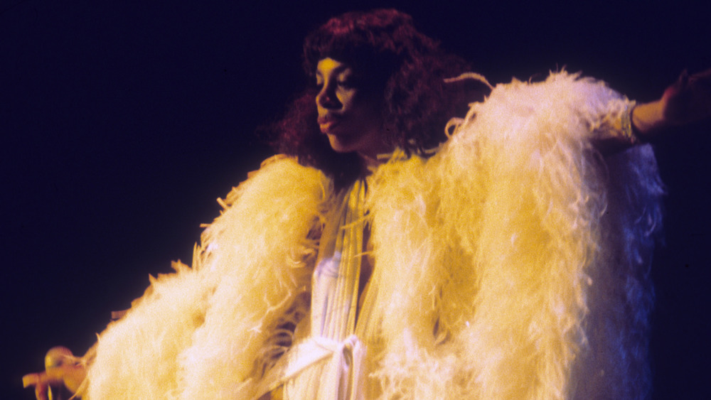 Donna Summer performs onstage in a feather costume