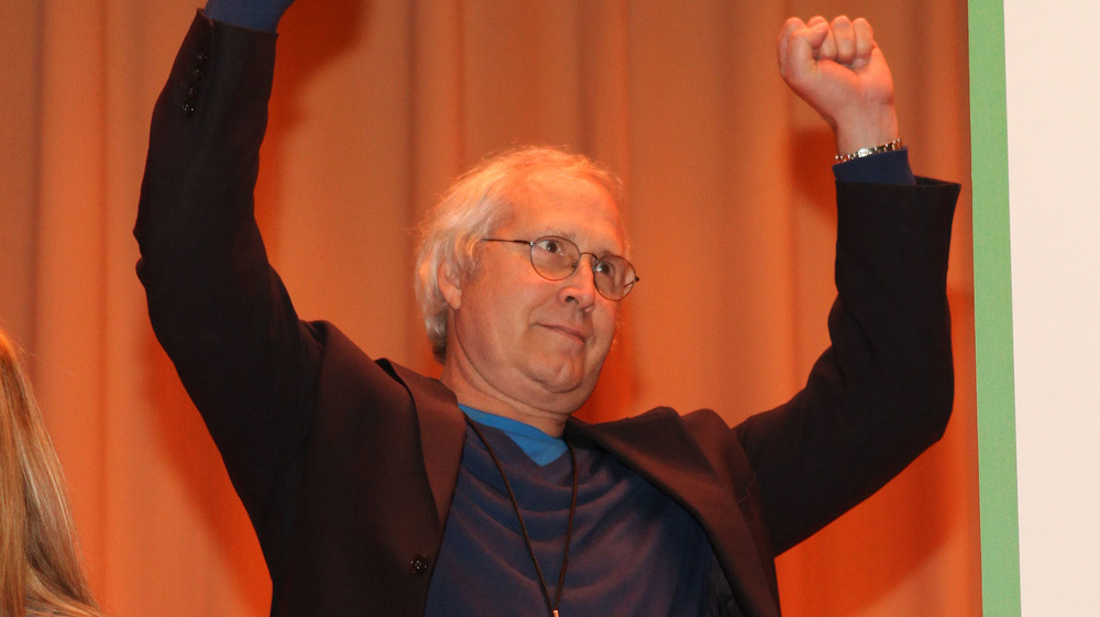 Chevy Chase with arms raised
