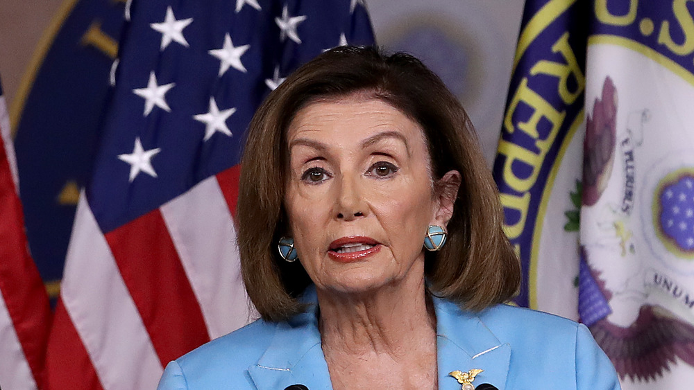 Nancy Pelosi in front of flags