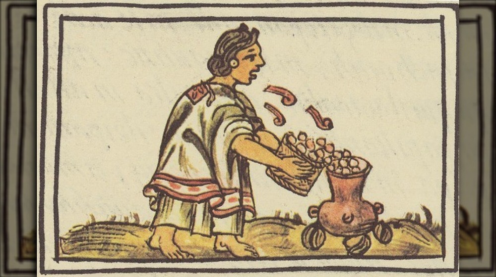 Aztec woman blowing on maize (corn) before putting it into the cooking pot
