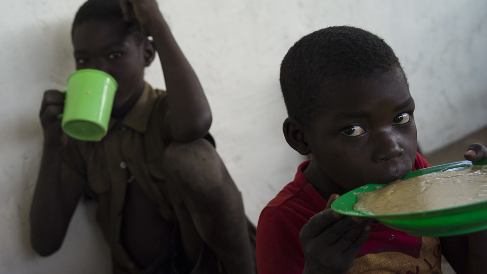 A photograph of young African boys having a meal.