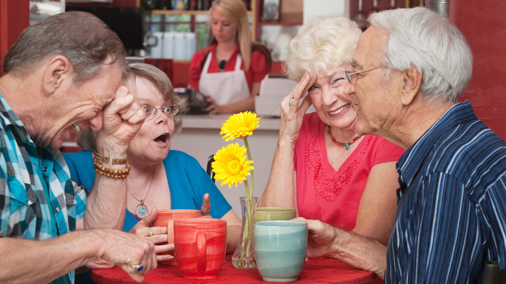 An elderly woman cringing at her friend's joke.
