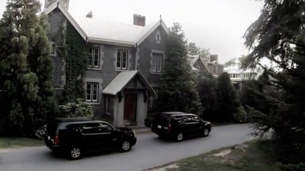 Victorian mansion with TAPS vehicles out front