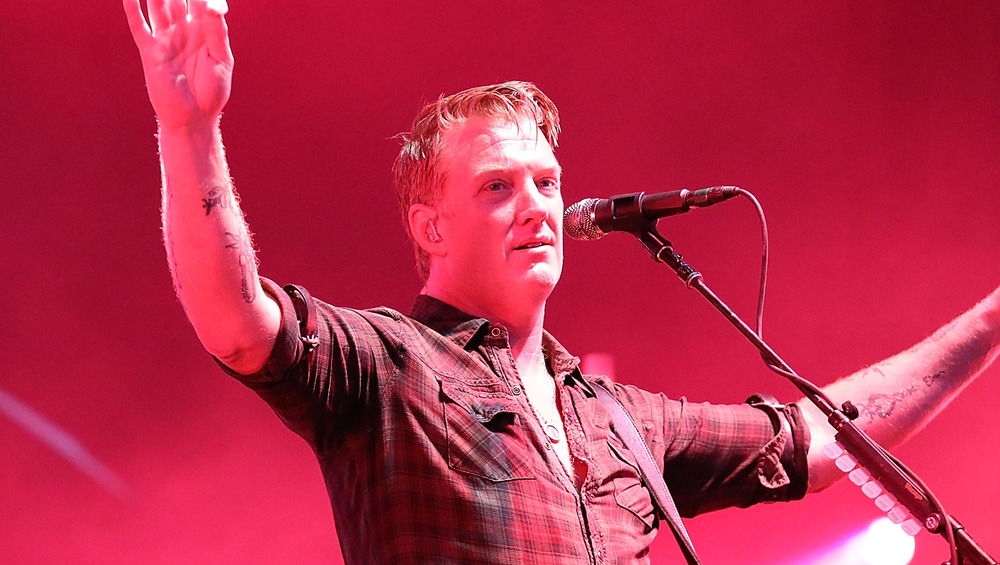 Josh Homme in front of red backdrop 