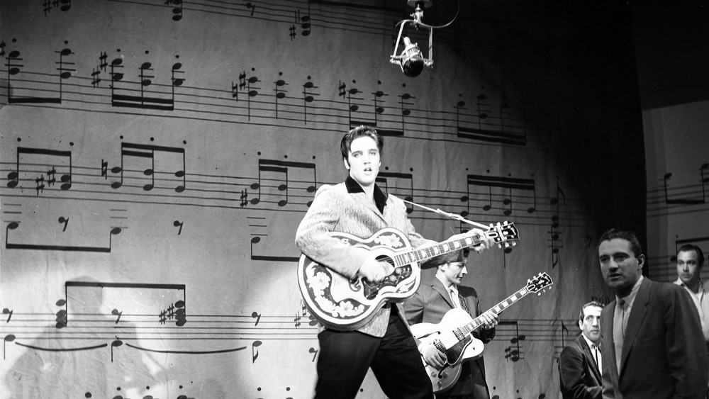 Elvis with guitar in hand on set of The Ed Sullivan Show