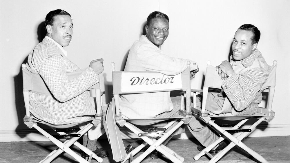 King Cole Trio sitting in director chairs