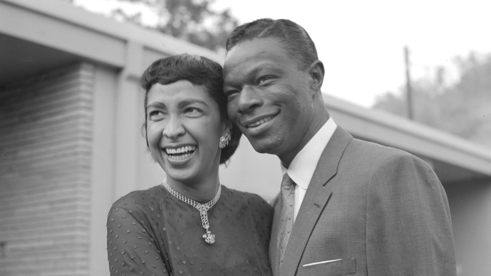 Nat King Cole and his wife Maria Cole embrace each other and pose for a photo