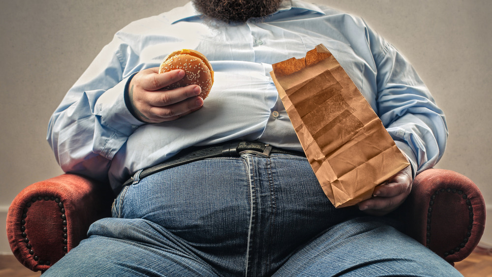 Obese man eating fast food