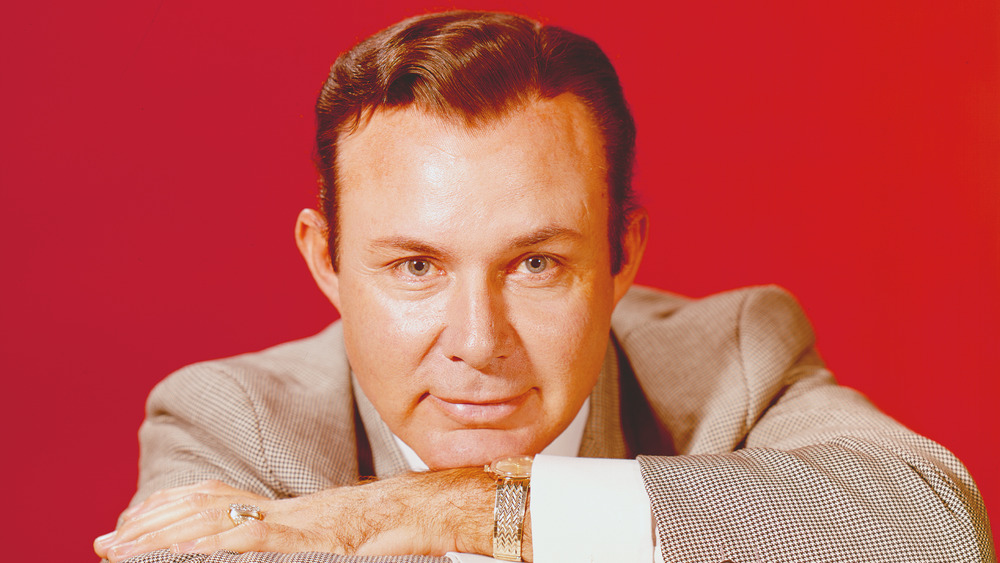 Jim Reeves in front of a red backdrop