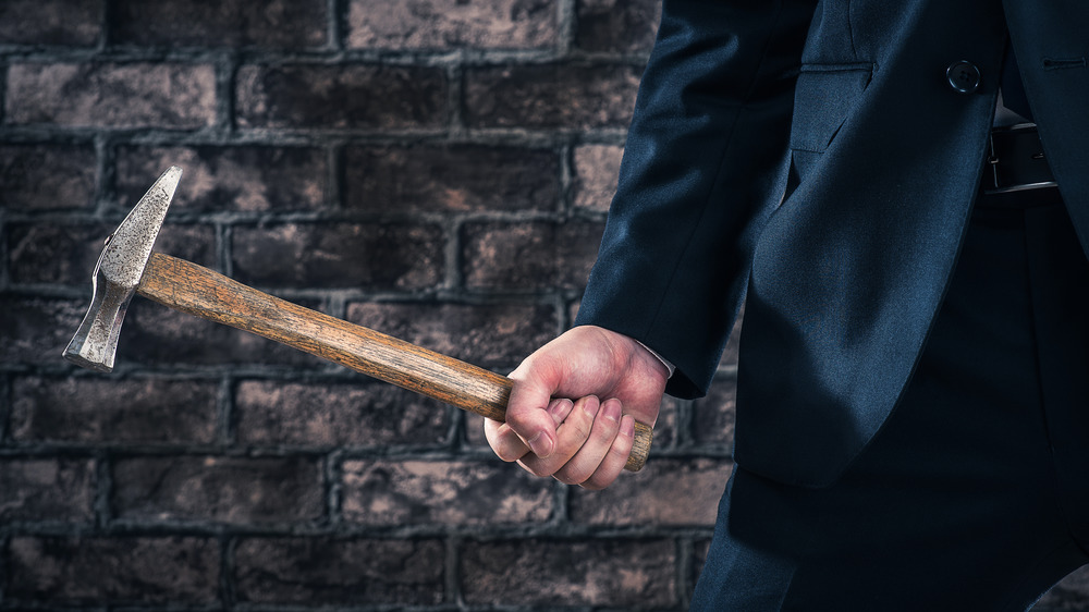 Nicely dressed man holding a hammer