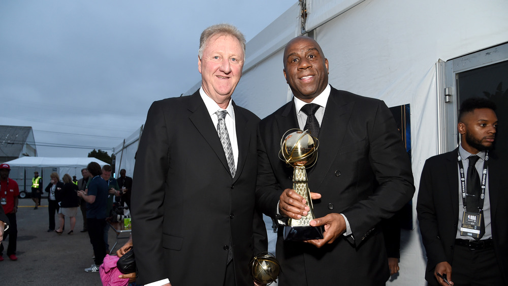 Magic Johnson and Larry Bird standing and smiling 