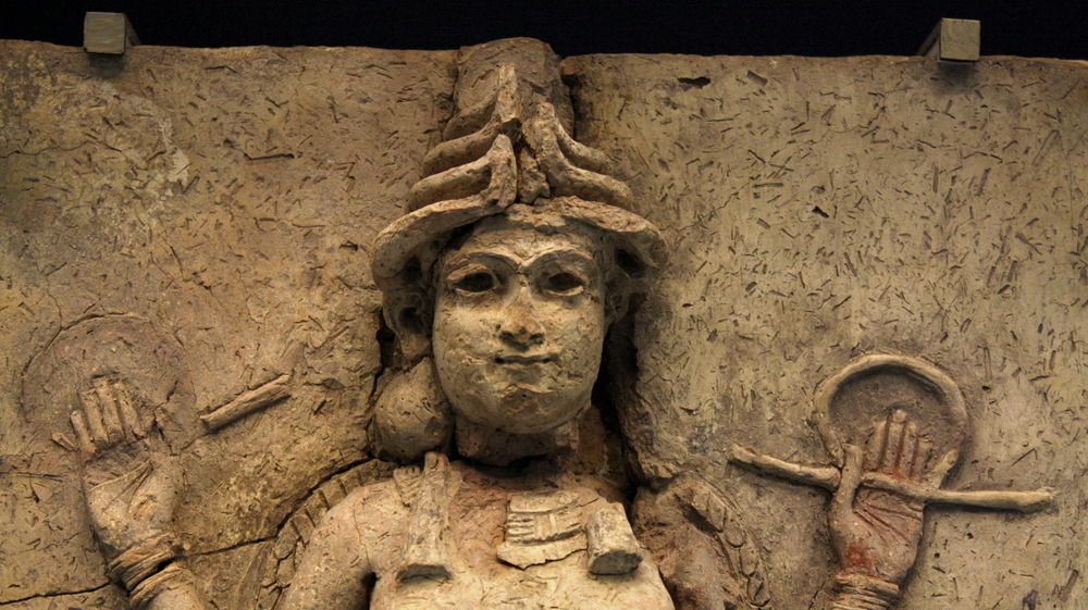 stone carving of Lilith with  hands in the air