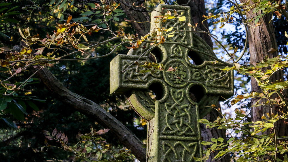 Celtic cross enshrouded in greenery