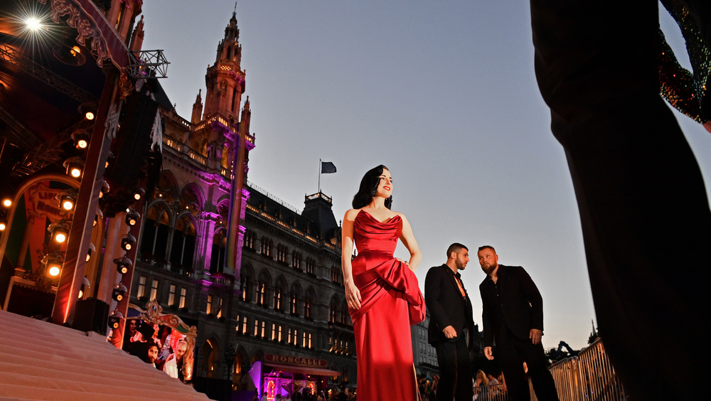 Dita Von Teese wearing a red dress and posing for pictures