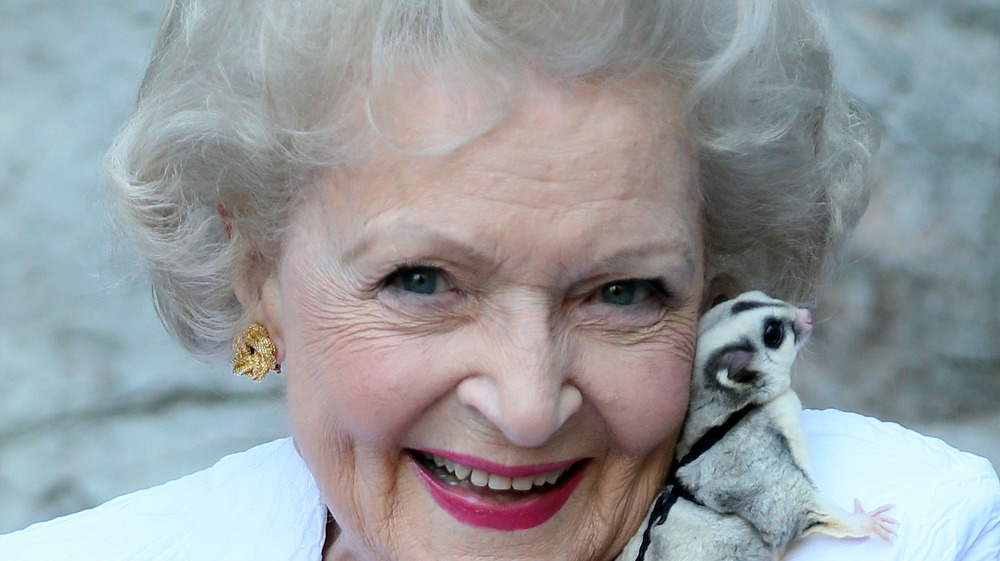 Betty White cuddling an animal 
