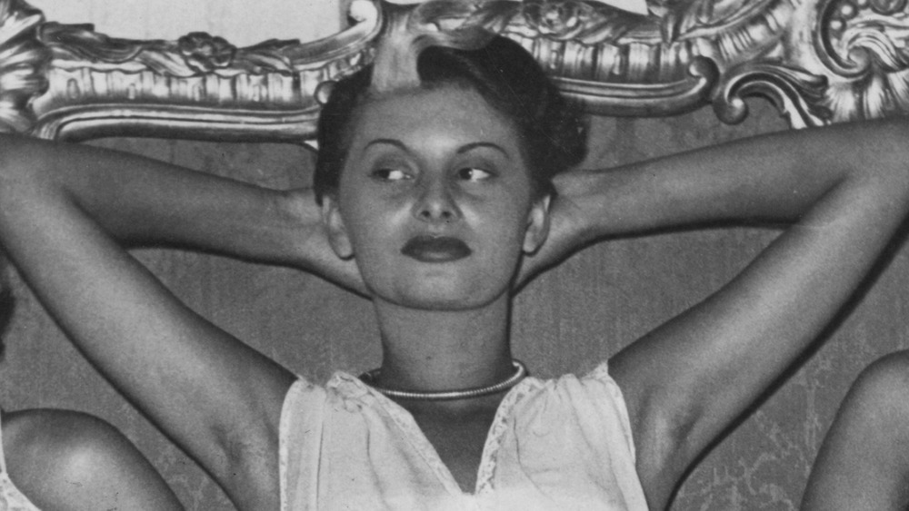 Sophia Loren giving side-eye, arms raised over head