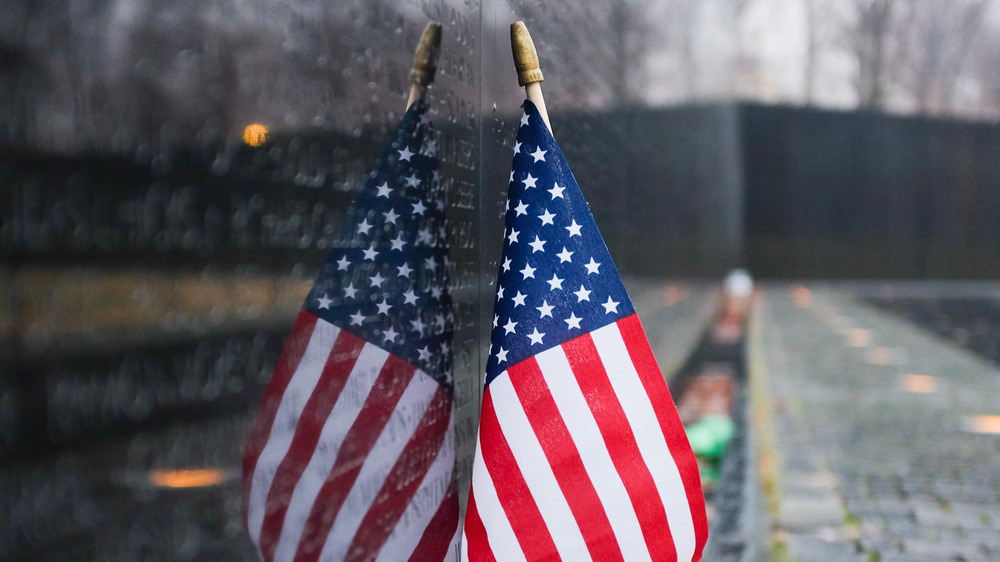 US flag leaning against the Vietnam War Memorial