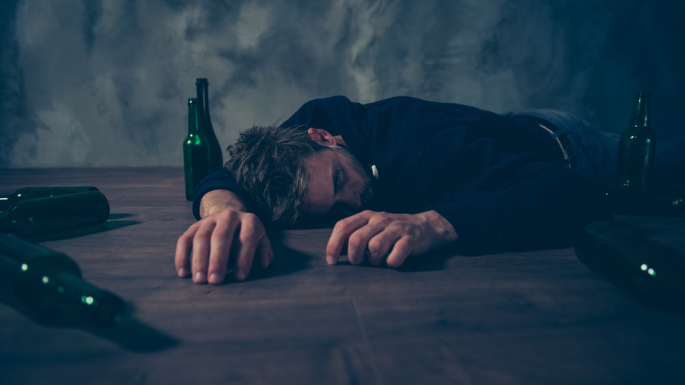 Man passed out surrounded by empty bottles