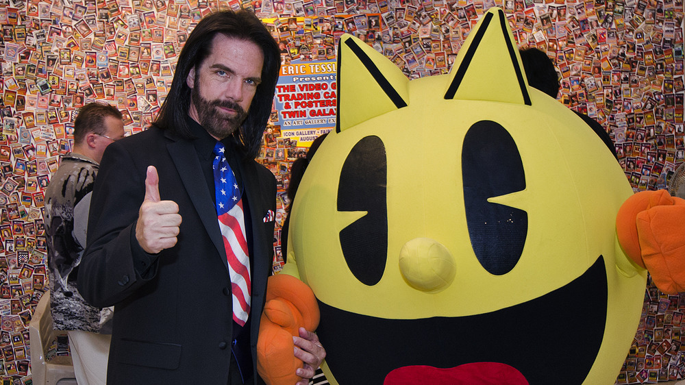 Billy Mitchell standing with Pac-Man