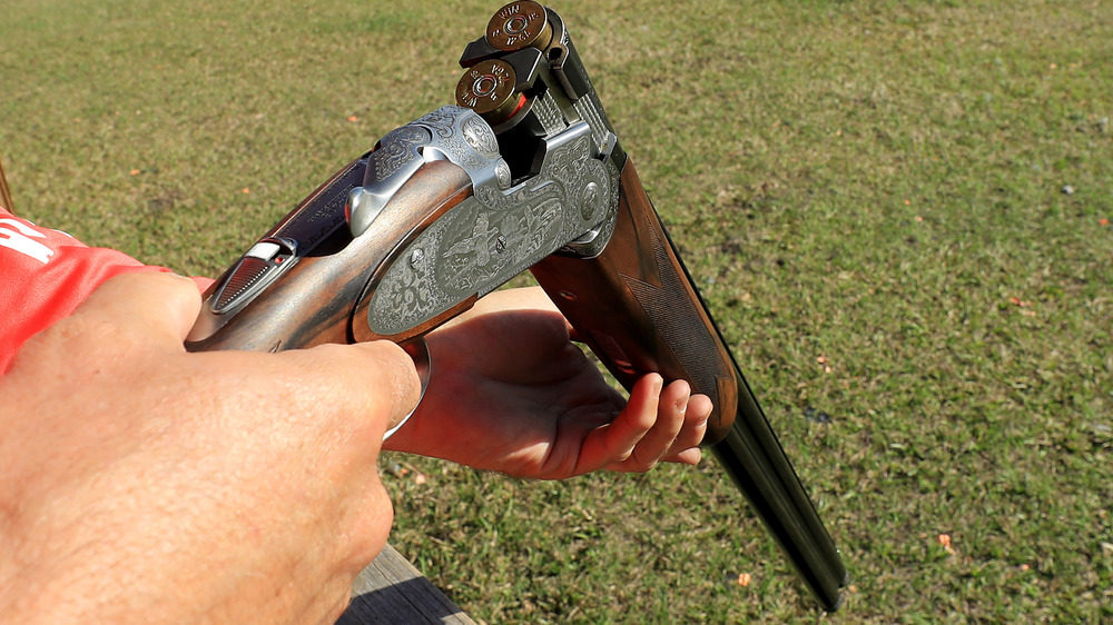 A loaded shotgun held in a man's hands