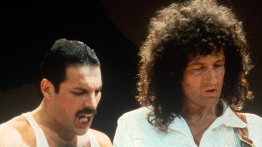 Brian May playing guitar on stage with Freddie Mercury