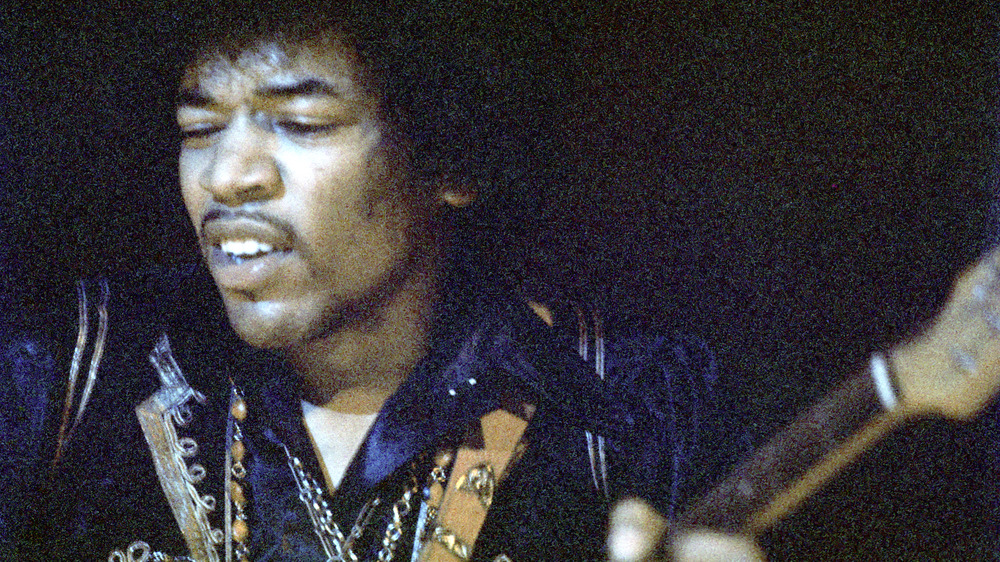 Jimi Hendrix performing with guitar