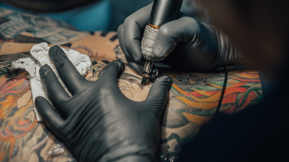 Artist tattooing a client