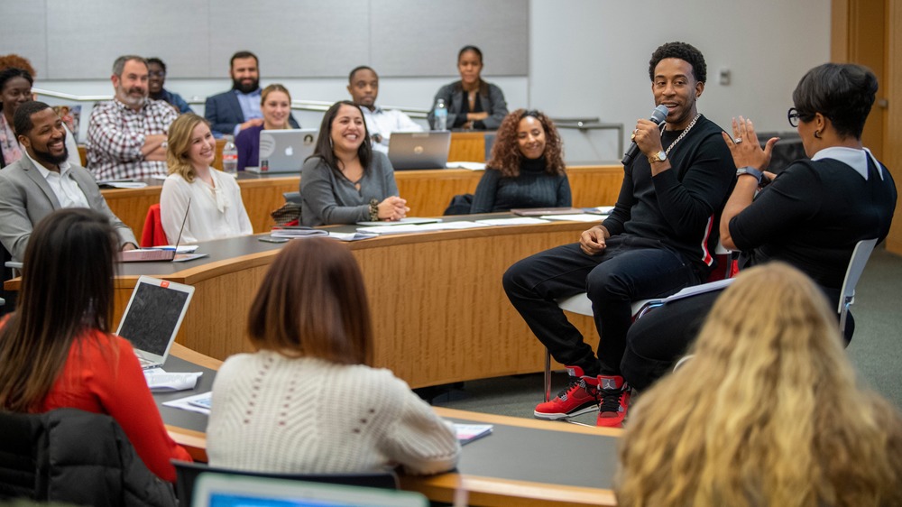Ludacris speaking in front of a class 