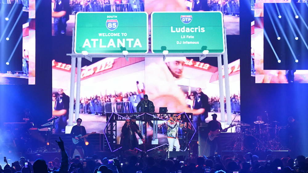 Ludacris, Lil Fate, and DJ Famous performing on a stage with 