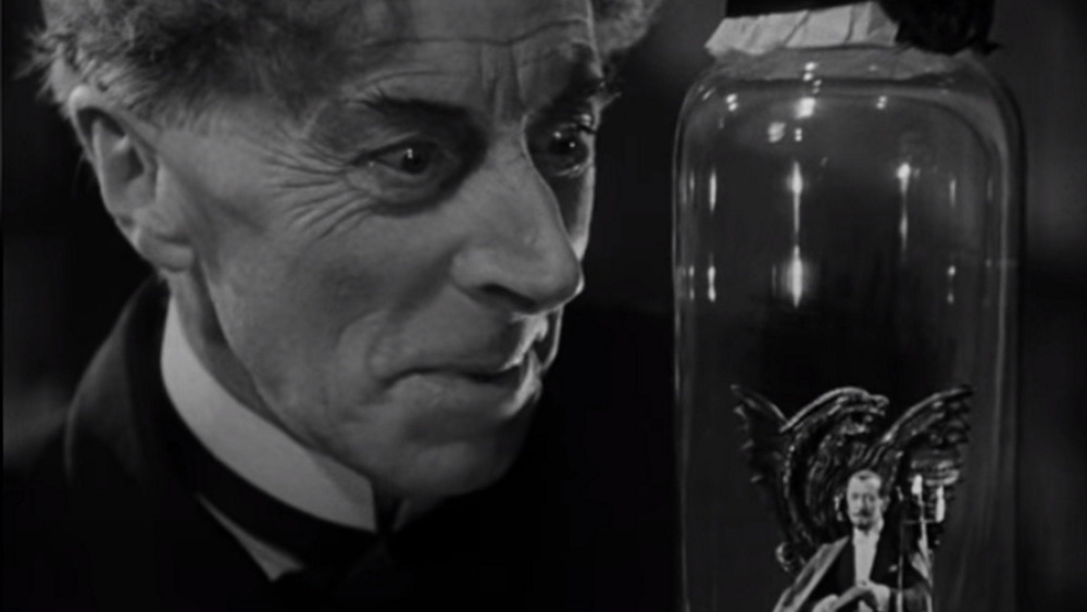 Ernest Thesiger as Dr. Septimus Pretorious looking in glass jar