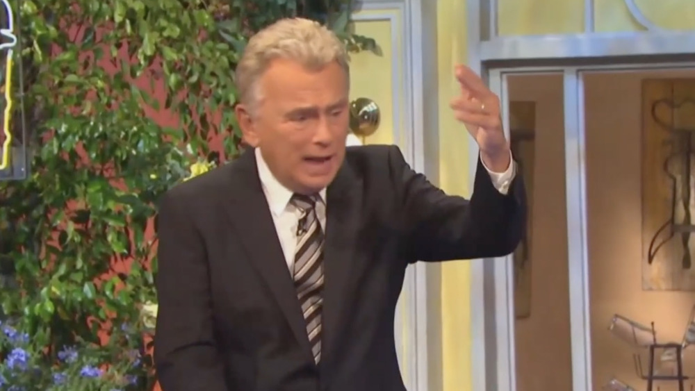 Pat Sajak with hand raised