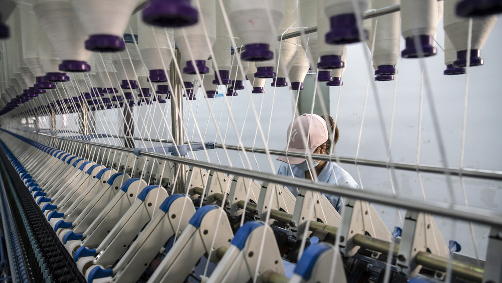 Factory worker using large loom