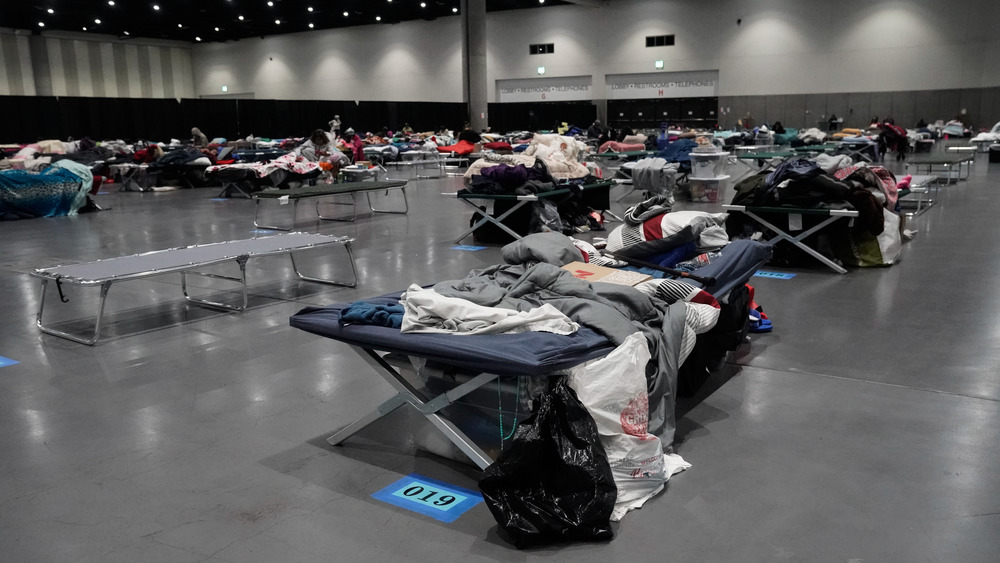 Cots on cement floor of homeless shelter