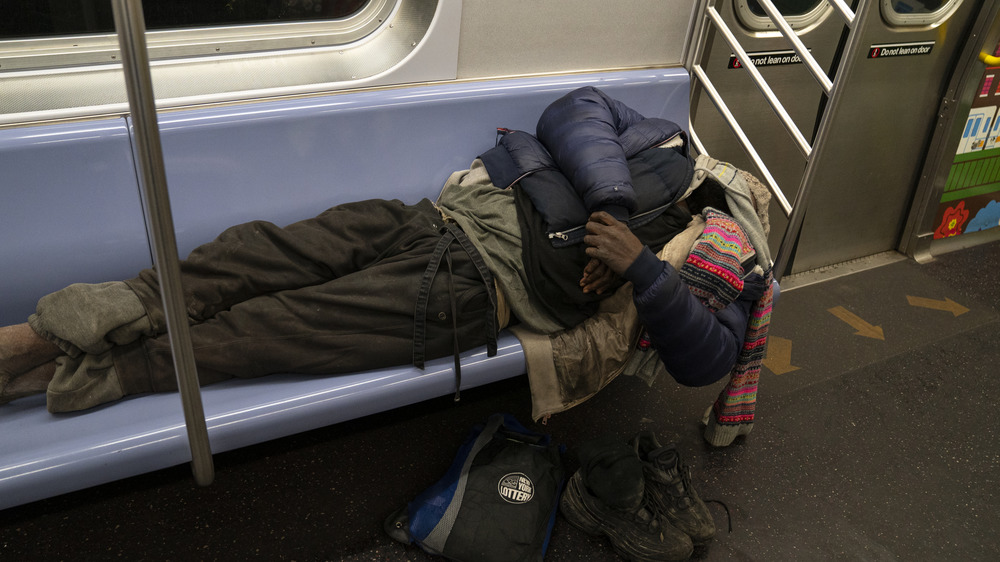 Homeless man sleeps on subway