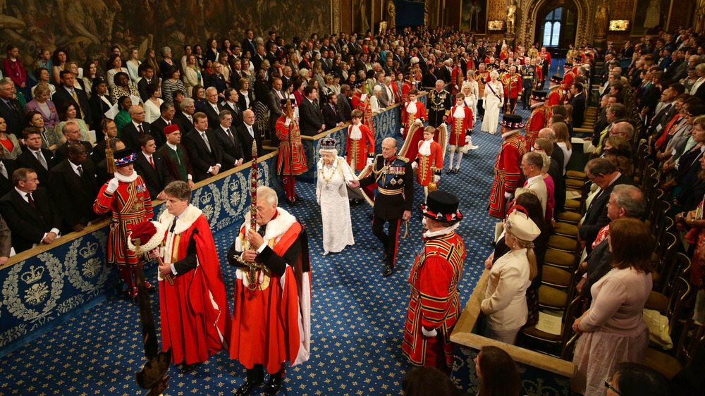 Queen Elizabeth II and the Prince Philip, Duke of Edinburgh proceed through the Royal Gallery during the State Opening of Parliament in the House of Lords at the Palace of Westminster on June 4, 2014 in London, England.